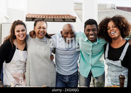 Küche im Freien: Afrikanische Familienkost auf der Terrasse zu Hause. Vater, Mutter, Töchter, Bruder, der gesundes Essen zubereitet Stockfoto