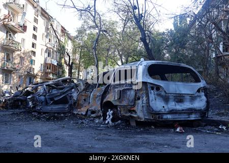 Kiew, Ukraine. Juli 2024. Ausgebrannte Autos werden vor einem fünfstöckigen Wohnblock im Bezirk Holosiivskyi nach einem russischen Raketenangriff in Kiew gesehen. Am Morgen führte die russische Armee einen Raketenangriff auf die ukrainischen Städte Kiew, Dnipro, Kryvyi Rih, Slowiansk, Kramatorsk, mit mehr als 40 Raketen verschiedener Art. In Kiew wurden Wohngebäude, Infrastrukturanlagen und das Kinderkrankenhaus „Okhmatdyt“ beschädigt. Retter suchen weiterhin nach Menschen unter den Trümmern. Quelle: SOPA Images Limited/Alamy Live News Stockfoto