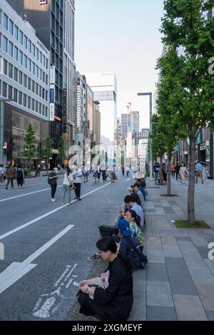 An einem lebhaften Samstag in Ginza, Tokio, sind die Straßen für den Verkehr gesperrt, so dass die Menschen entspannen und die lebhafte Atmosphäre in modernem Gebäude genießen können Stockfoto