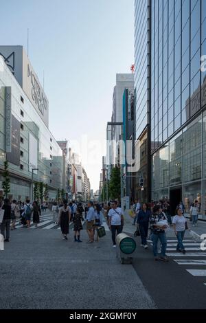 An einem lebhaften Samstag in Ginza, Tokio, sind die Straßen für den Verkehr gesperrt, so dass die Menschen entspannen und die lebhafte Atmosphäre in modernem Gebäude genießen können Stockfoto