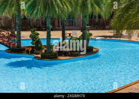 Phuket Thailand. Swimmingpool mit Palmen. Tropischer Pool mit Bäumen. Palmen für den Swimmingpool. Wasserpool mit Palmen. Deck Chai Stockfoto