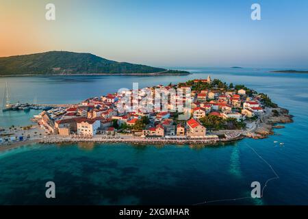 Primosten, Kroatien - aus der Vogelperspektive auf die Halbinsel Primosten und die Altstadt an einem sonnigen Sommermorgen in Dalmatien, Kroatien. Blauer und goldener Himmel bei Sonnenaufgang Stockfoto