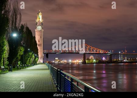 Der alte Hafen von Montreal Clock Tower und die Jacques Cartier Bridge sind bei Nacht beleuchtet. Montreal, Quebec, Kanada. Stockfoto