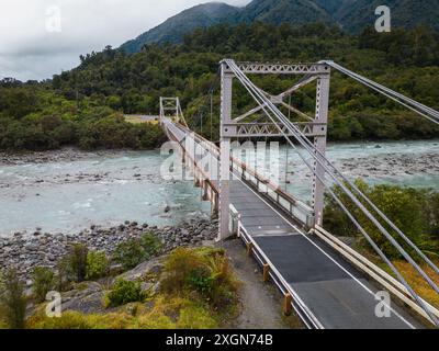 Fox Glacier, Neuseeland: Drohnenblick über die Brücke über den Karangarua River in der Nähe des Fox Glacier in der Südinsel Neuseelands wilde Westküste. Stockfoto