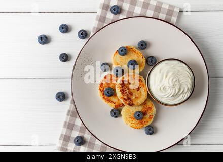 Hüttenkäse Pfannkuchen, mit Blaubeeren, Frühstück, auf einem weißen Holztisch, keine Leute, Blick von oben Stockfoto