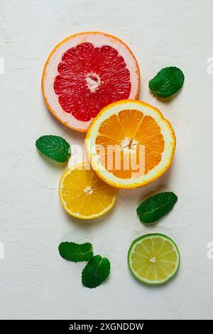 Lebensmittelkonzept, Tapete, geschnittene Zitrusfrüchte, Blick von oben, auf einem Leuchttisch, mit Minzblättern, Essenshintergrund Stockfoto