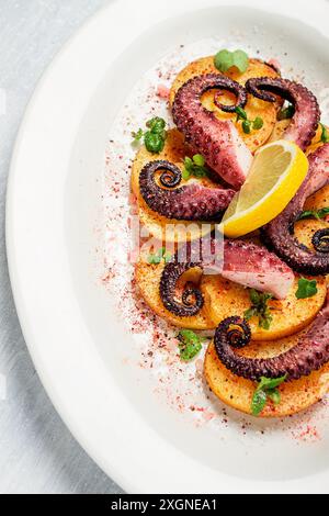 Oktopus mit Kartoffeln und Gewürzen, auf einer Leuchtplatte, Draufsicht, keine Leute, hausgemacht, Nahaufnahme Stockfoto