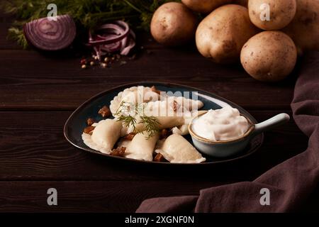 Traditionelles polnisches Gericht, Teigtaschen mit Kartoffeln, auf einem Holztisch, Nahaufnahme, mit Zutaten, keine Leute Stockfoto