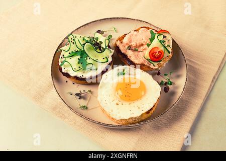 Auswahl an Sandwiches, Weißbrot, Spiegelei, Frischkäse und Gurke, Capelin Kaviar, Sesambrötchen, Frühstück, auf einem weißen Tisch, keine Leute Stockfoto