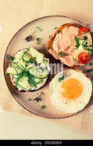 Auswahl an Sandwiches, Weißbrot, Spiegelei, Frischkäse und Gurke, Capelin Kaviar, Sesambrötchen, Frühstück, auf einem weißen Tisch, keine Leute Stockfoto