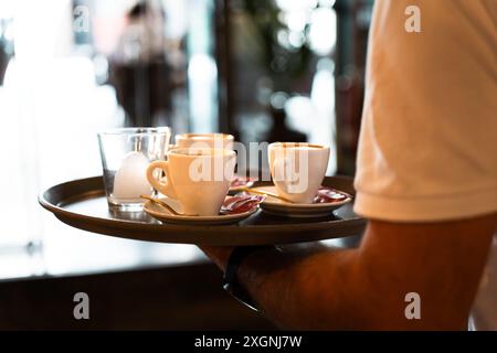Nahaufnahme eines Tabletts mit Kaffee, der von einem Kellner gehalten wird Stockfoto