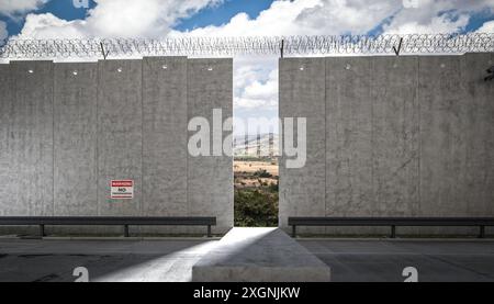 Hohe Betonrandwand über Stacheldraht Lücke führende Landschaft 3d Stockfoto