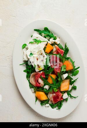 Salat, Melone mit Schinken, Rucola und Käse, Sommersalat, vegetarisch, selbstgemacht, keine Leute Stockfoto