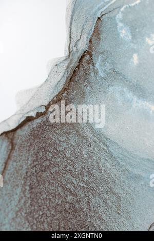 Ein abstraktes Kunstwerk mit einem Wirbel aus blauer und brauner Tinte, das ein organisches und strukturiertes Design schafft Stockfoto