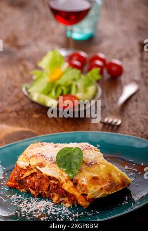 Ein Teil italienischer Lasagne auf einer blauen Platte Stockfoto