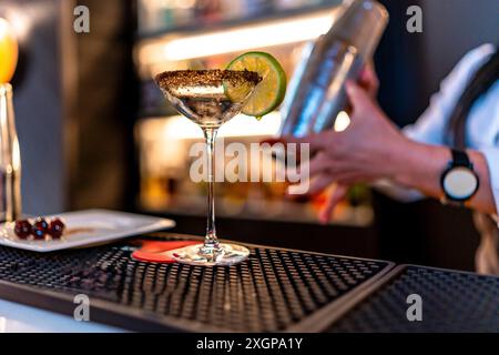 Nicht erkennbarer Barkeeper, der in einer luxuriösen Nachtbar einen Cocktail mit Shaker mixte Stockfoto