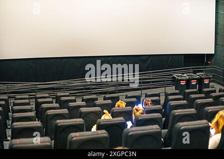 Die Zuschauer sitzen in der Kinohalle mit einer 3D-Brille mit Popcorn und einem Drink, bevor sie sich anschauen. Familienwochenende Stockfoto