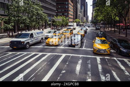 Gelbe Taxis hielten an einer Kreuzung im Verkehr von Midtown Manhattan; berühmte New York City City Straßenszene mit Wolkenkratzern, NYC, USA Stockfoto