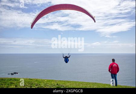 Extremsport. Paragliding, geboren im 20. Jahrhundert, aufgrund des Erfindungsreichtums der Bergsteiger, die nach unten fliegen wollten. Gijón, Asturien, Spanien. Stockfoto