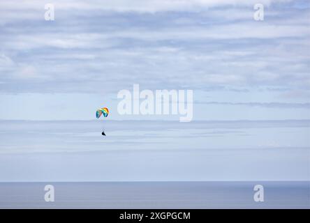 Extremsport. Paragliding, geboren im 20. Jahrhundert, aufgrund des Erfindungsreichtums der Bergsteiger, die nach unten fliegen wollten. Gijón, Asturien, Spanien. Stockfoto