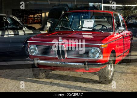 ROSKILDE, DÄNEMARK - 30. OKTOBER 2014: Der rote BMW 1602 wurde im Händlerbetrieb vorgestellt und durch das Glas der Schaufensterfront geführt Stockfoto