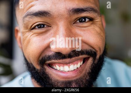 Nahaufnahme eines jungen, birassischen Mannes, der in die Kamera lächelt. Sein fröhlicher, unveränderter Ausdruck verleiht dem Bild eine warme, persönliche Note. Stockfoto