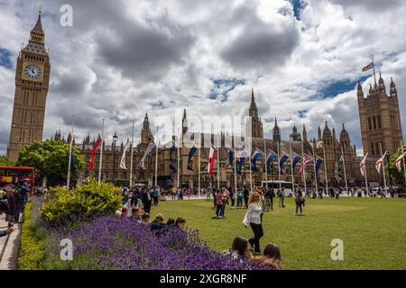 Parliament Square gegenüber Big Ben & The Houses of Parliament, ein Treffpunkt für Demonstrationen und den Blick auf die Flaggen und Statuen, London UK Stockfoto