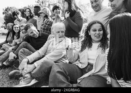 Gruppe von Menschen mit mehreren Generationen, die gemeinsam Spaß haben - multirassische Freunde unterschiedlichen Alters lächeln im Freien - Hauptfokus auf afrikanisches kurviges Mädchengesicht Stockfoto