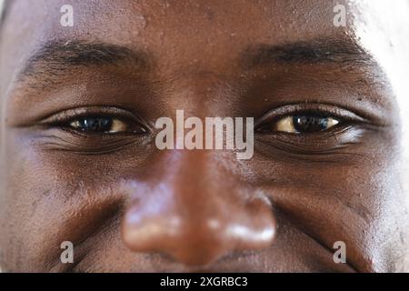 Porträt Nahaufnahme der Augen eines glücklichen afroamerikaners in der Sonne lächelnd. Wohlbefinden, Wohlergehen und Lebensstil unverändert. Stockfoto