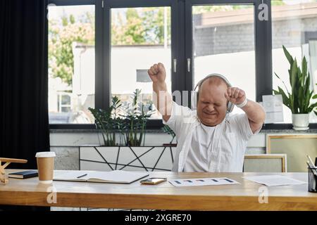 Ein Mann mit Inklusivität tanzt in seinem Büro und genießt eine Pause von der Arbeit. Stockfoto