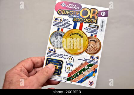 Frankreich. Juli 2024. In dieser Fotoabbildung hält ein Mann ein Ticket vom Objectif- oder Scratch-Spiel in der Hand. Objectif OR ist ein neues Scratch-Spiel, das von Francaise des Jeux (FDJ) für die Olympischen Spiele 2024 in Paris angeboten wird. Verkauft für 5 Euro, können die Glücklichen Gewinne von bis zu 500 000 Euro einheimsen. (Foto von Gerard Bottino/SOPA Images/SIPA USA) *** ausschließlich für redaktionelle Nachrichten *** Credit: SIPA USA/Alamy Live News Stockfoto