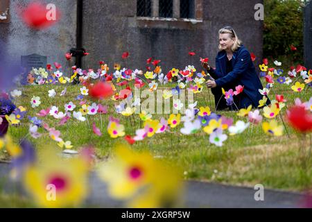 Dowland, Großbritannien, 10. Juli 2024. Die Dorfbewohner haben eine erstaunliche Wiese mit 7000 Papierblumen (3500 innen und 3500 außen) geschaffen, die in der St. Peter’s Church, Dowland, Devon, Großbritannien, ausgestellt werden. Die Ausstellung wird helfen, Mittel für die Wohltätigkeitsorganisationen Peter’s Patch, Papyrus und Mind zu sammeln. Die Organisatoren der Ausstellung, so die farbenfrohe Ausstellung, seien symbolisch für die Mission Peter’s Patch, Kindern die Natur näher zu bringen. Abgebildet ist Sue Dunn (Schatzmeister - Peter's Patch Childrens Group) mit den Blumen. Stockfoto