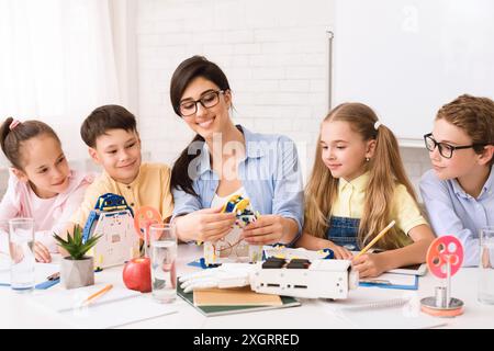 Lehrer, der junge Schüler im Robotik-Unterricht betreut Stockfoto