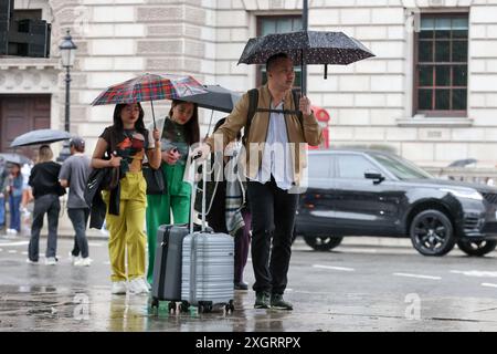 London, Großbritannien. Juli 2023. Touristen übernachten unter Sonnenschirmen im Zentrum von London an einem regnerischen Tag in der Hauptstadt. Die neuesten Daten von MET Office zeigen, dass London in den ersten acht Tagen des Monats 86 Prozent seiner durchschnittlichen Regenfälle im Juli verzeichnete, da eine gelbe Wetterwarnung auf viele Teile Großbritanniens ausgedehnt wurde. Quelle: SOPA Images Limited/Alamy Live News Stockfoto