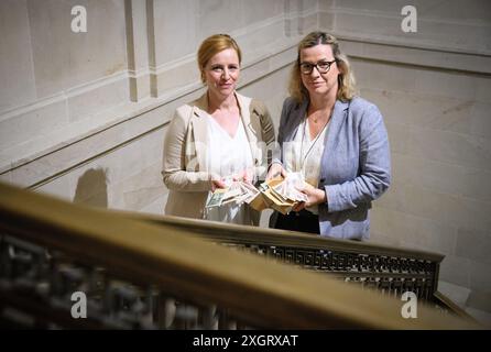 PRODUKTION - 10. Juli 2024, Berlin: Christine Volk (l), Pressesprecherin der KfW, und Lysann Goldbach, Leiterin des historischen Archivs der KfW-Gruppe, stehen mit DDR-Markenbündeln in der Berliner Kreditanstalt für Wiederaufbau (KfW). Im Frühjahr 1990 begann die DDR-Landesbank, das ostdeutsche Papiergeld in einem alten Tunnel in Halberstadt (Sachsen-Anhalt) hinter dicken Betonmauern zu lagern, wo es verrotten sollte. Seit der währungsunion am 1. Juli 1990 wurde die D-Mark auch als Zahlungsmittel im Osten genutzt, die Ost-Mark war kurz darauf wertlos. Trotzdem, 11 Jahre Stockfoto