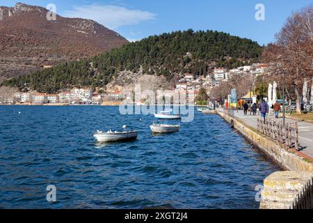 Blick auf den See Orestiada, in Kastoria Stadt, mit Fischerbooten und Einheimischen, die den Kai entlang schlendern. Stockfoto