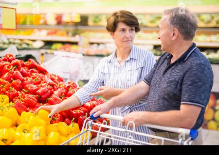 Ein älteres Paar kauft im alkoholischen Gemüse eines Supermarkts Paprika Stockfoto