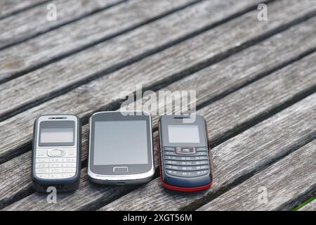 Veraltete Handys auf einem alten verwitterten Holztisch Stockfoto