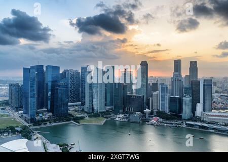 Fantastischer Blick aus der Luft auf Marina Bay und Wolkenkratzer der Innenstadt bei Sonnenuntergang. Fantastische Skyline von Singapur. Fantastisches Stadtbild. Stockfoto