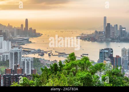 Fantastischer Blick auf die Skyline von Hongkong und den Victoria Hafen bei Sonnenuntergang. Wolkenkratzer in der Innenstadt sind auf dem orangefarbenen Hintergrund zu sehen. Wunderschönes Stadtbild. Stockfoto