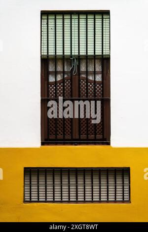 Ein traditionelles spanisches Fenster mit Holzläden und schmiedeeisernen Gittern Stockfoto