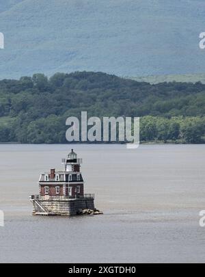 Hudson–Athens Lighthouse (Stadtlicht) im Hudson River mit Hügeln im Hintergrund (berühmtes Wahrzeichen Tal im Norden), Leuchtturm von leichten Führungsbooten und Stockfoto