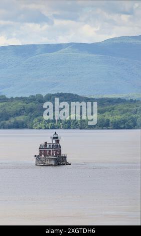 Hudson–Athens Lighthouse (Stadtlicht) im Hudson River mit Hügeln im Hintergrund (berühmtes Wahrzeichen Tal im Norden), Leuchtturm von leichten Führungsbooten und Stockfoto