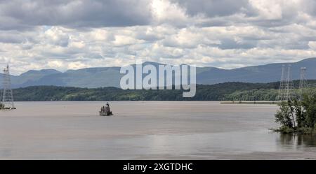 Hudson–Athens Lighthouse (Stadtlicht) im Hudson River mit Hügeln im Hintergrund (berühmtes Wahrzeichen Tal im Norden), Leuchtturm von leichten Führungsbooten und Stockfoto