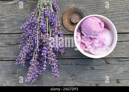 Eis mit Lavendelgeschmack und Blumenstrauß mit Lavendelgeschmack auf einem alten Holztisch. Stockfoto