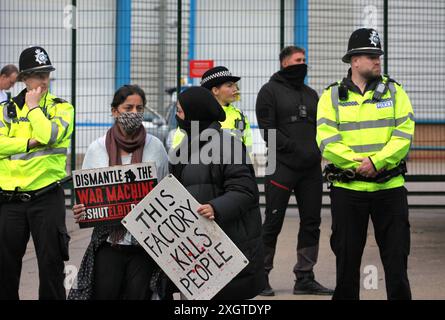 Leicester, Leicestershire, Großbritannien. Juli 2024. Polizisten und Elbit Security schützen den Eingang zur Fabrik, während Demonstranten während der Demonstration Schilder gegen Elbit Systems halten. Demonstranten versammeln sich vor den Toren der Fabrik von Elbit System in Leicester, um zu protestieren, während Arbeiter bei der israelischen Rüstungsfirma arbeiten. Die Demonstranten protestieren gegen die Waffen, die in dieser Fabrik hergestellt wurden, die ihrer Meinung nach später zur Unterdrückung der Palästinenser in Gaza und anderswo eingesetzt werden. 85 % der israelischen Drohnenflotte werden von Elbit Systems beliefert, und die Demonstranten wollen ihre sieben verbleibenden Geschäfte Stockfoto