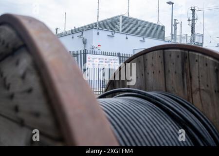 10. Juli 2024, Bayern, Donauwörth: Vor dem Stellwerk liegt eine Trommel mit Signalkabel. Die Deutsche Bahn stellt Deutschlands erstes digitales Stellwerk auf einer Hochgeschwindigkeitsstrecke vor. Foto: Stefan Puchner/dpa Stockfoto