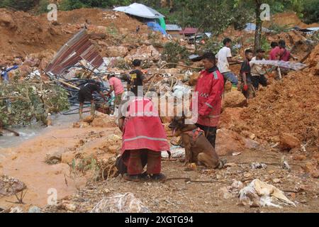 (240710) -- GORONTALO, 10. Juli 2024 (Xinhua) -- Polizei und ein Schnüffelhund führen Rettungsaktionen durch, nachdem am 10. Juli 2024 ein Erdrutsch das Dorf Tulabolo in der Provinz Bone Bolango, Indonesien, getroffen hatte. Indonesien hat am Dienstag die Zahl der Retter fast verdoppelt und schwere Maschinen und einen Hubschrauber eingesetzt, um nach Opfern von Erdrutschen und Sturzfluten in der Provinz Gorontalo zu suchen, so ein leitender Retter. (Polizei von Gorontalo/Handout Via Xinhua) Stockfoto