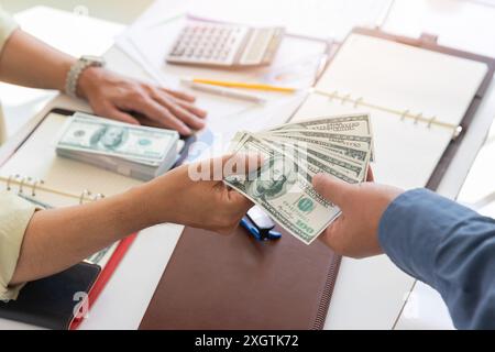 Ein Mann, der Hundert Dollar-Scheine anbietet. Hand eines Geschäftsmannes, der seinem Partner Geld gibt. Hand erhält Geld vom Geschäftsmann. Bestechung, Bestechung, Stockfoto