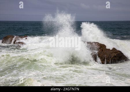 Dramatische Wellen brechen auf den Felsen an der Küste Portugals in Foz, Porto Stockfoto